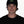 Person wearing a black beanie with a logo on a white background