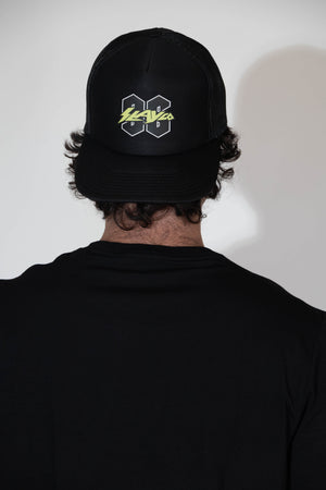 Person wearing a black cap with a logo on the back against a white background