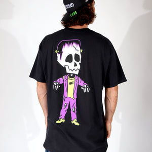 Person wearing a black t-shirt with a colorful skeleton design on the back, standing against a white background. Halloween frankenstein