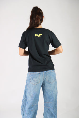 Person wearing a black t-shirt  halloween skull with text and blue jeans on a white background