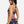 Woman wearing a sports bra and shorts with colorful designs on a white background